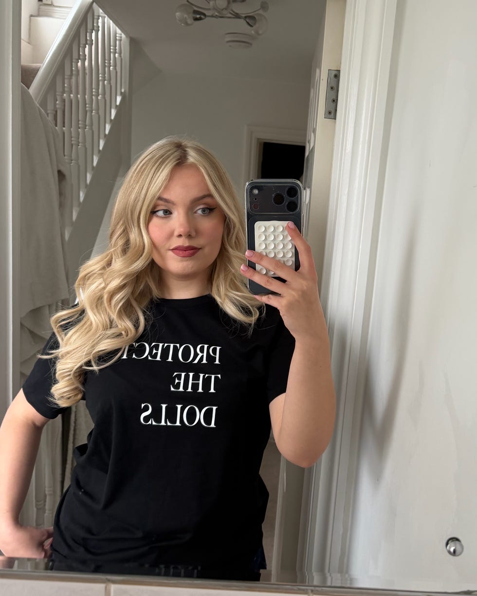 a person taking a selfie in a mirror wearing a black tshirt with a message