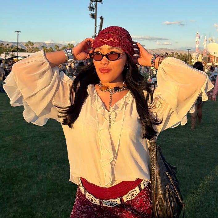 Individual posing in a festival environment with a vibrant background.