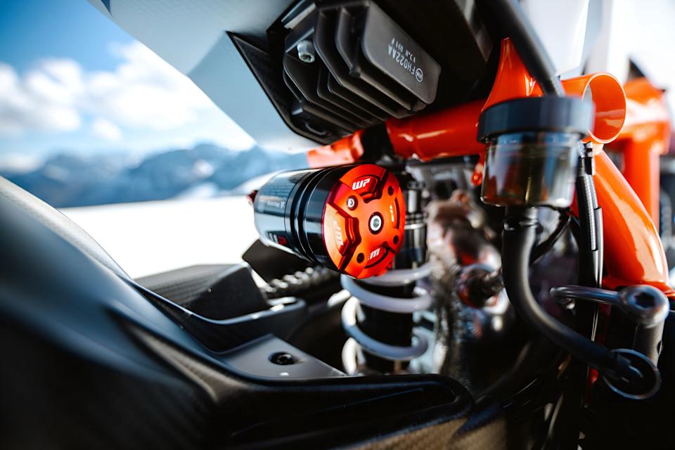 Close-up of a motorcycle suspension component with a red WP branded adjustment knob and white coil spring.