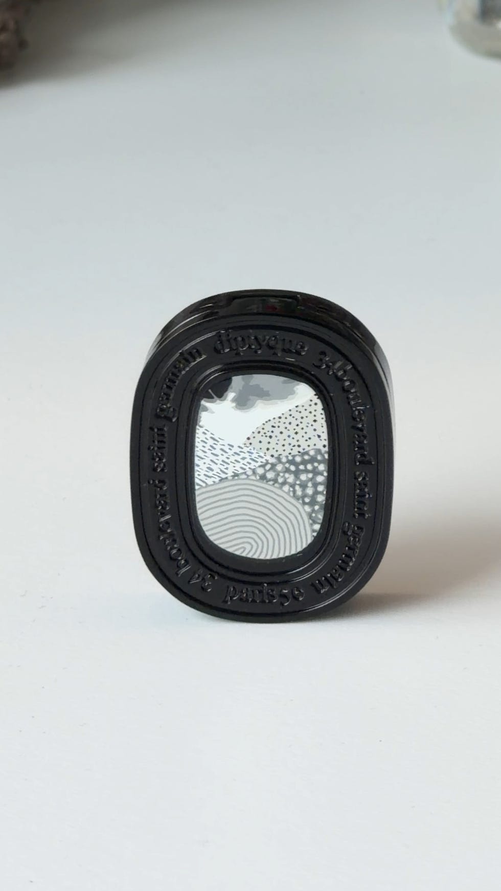 Glossy container with artistic design.