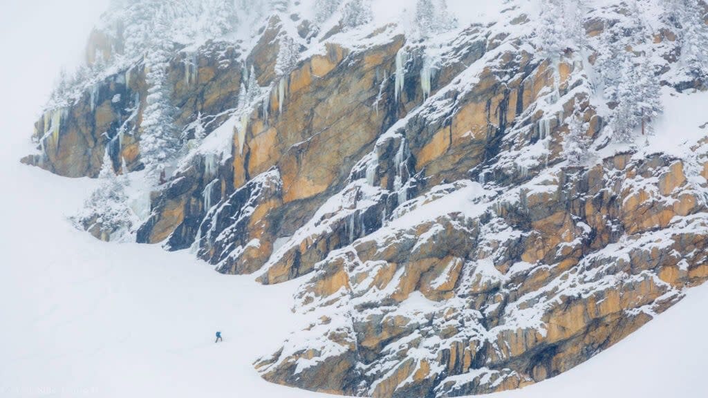 hikers high above the lake on a snowfield in rocky mountain national park