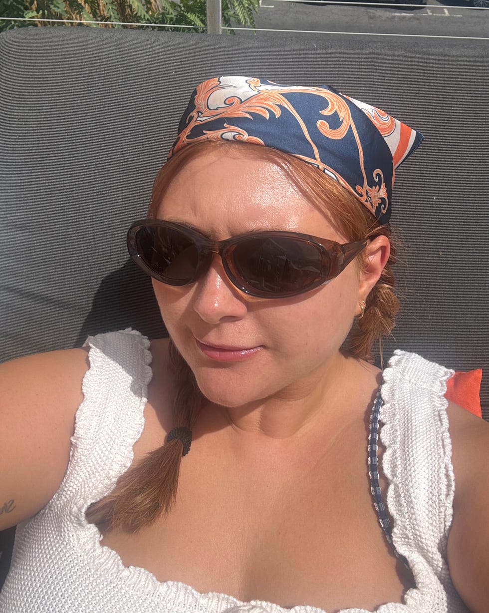 A person lounging in an outdoor setting with a decorative headscarf.