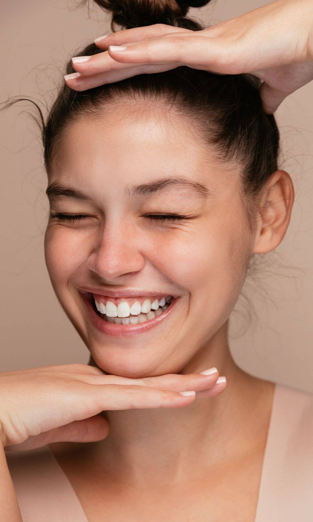 Model with beautiful skin laughing with her eyes closed