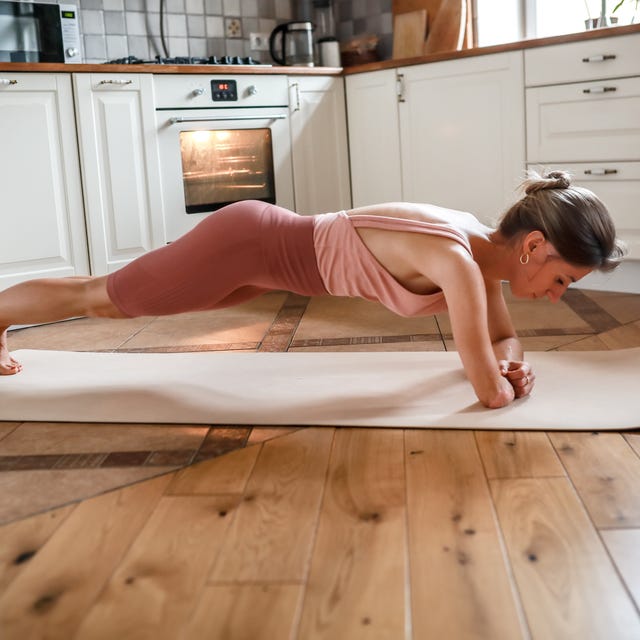 Unyielding Power: Amputee Woman's Yoga Practice in the Comfort of Her Kitchen, Mastering Plank Pose with One Arm.