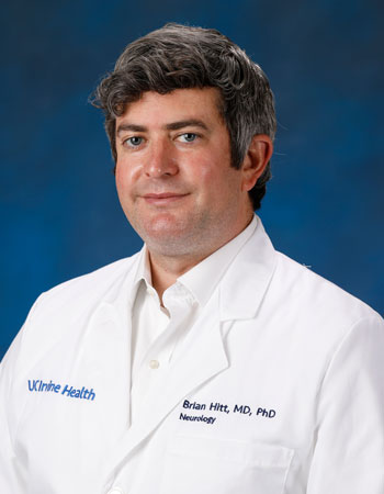 uci health neurologist dr brian hitt wearing a white coat in front of a blue studio background