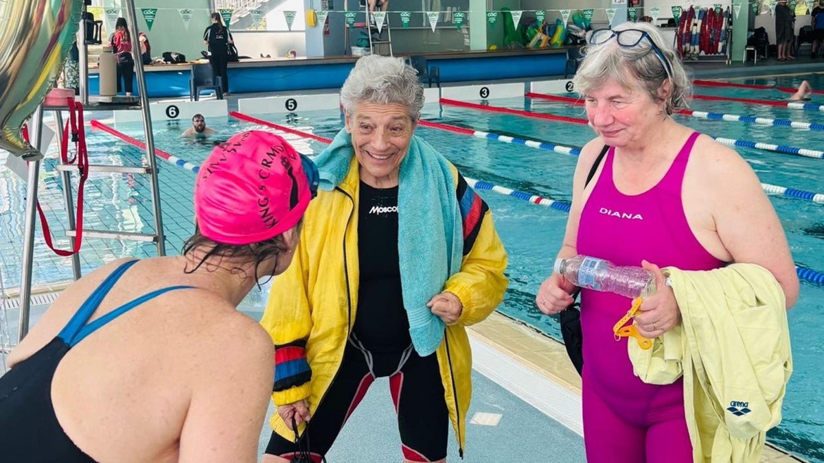 Jane Asher with her swim friends talking outside the pool.