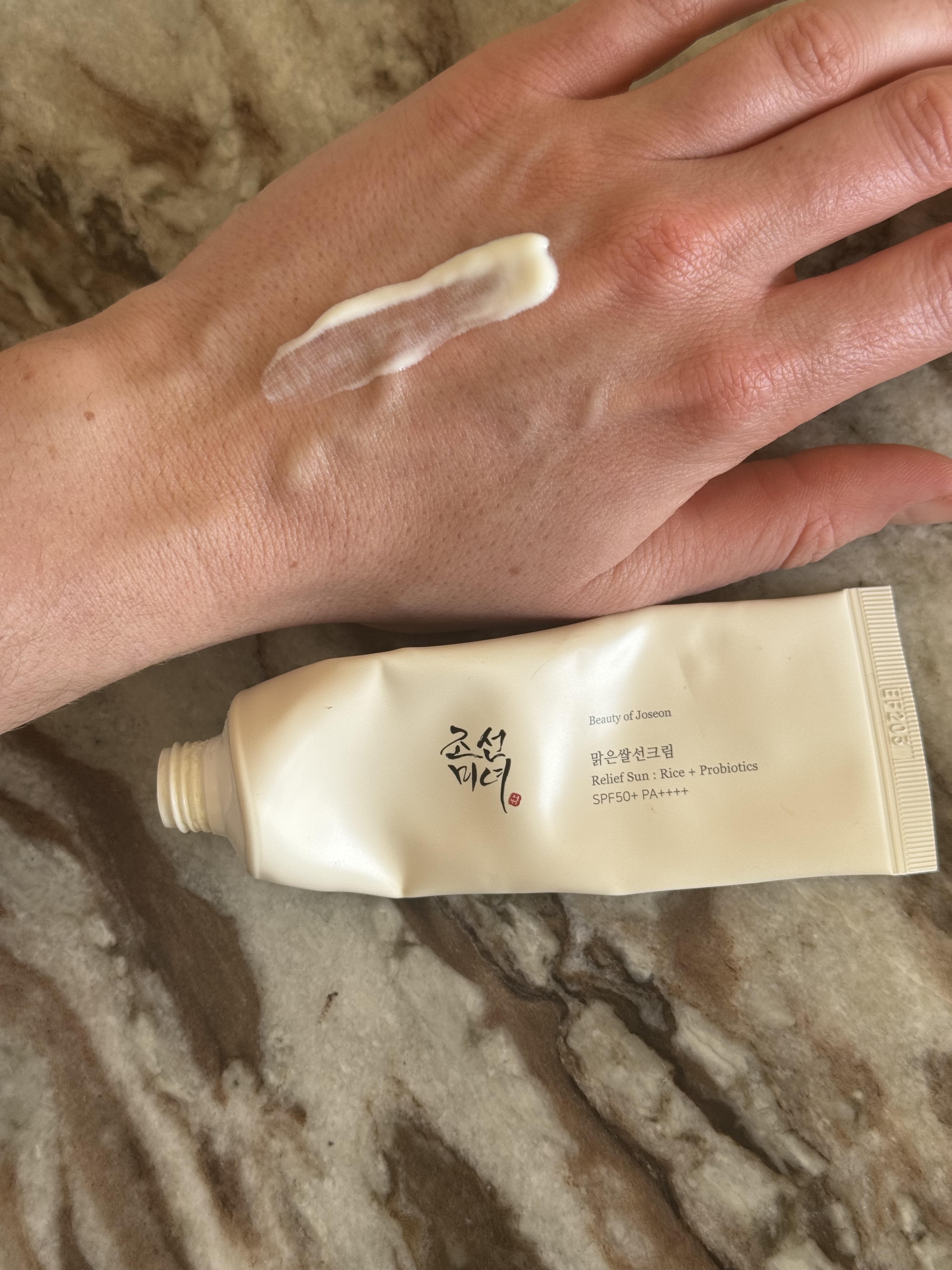 A swatch of the Beauty of Joseon Relief Sun Rice + Probiotics SPF 50 on the back of Eleanor's hand