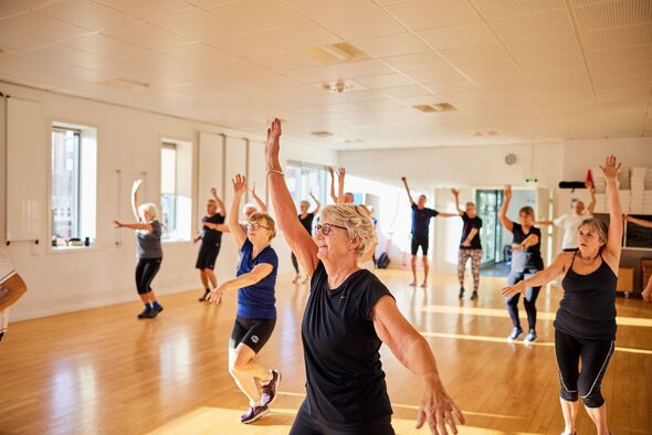 Smiling seniors taking an exercise class at the gym Smiling seniors taking an exercise class at the gym
