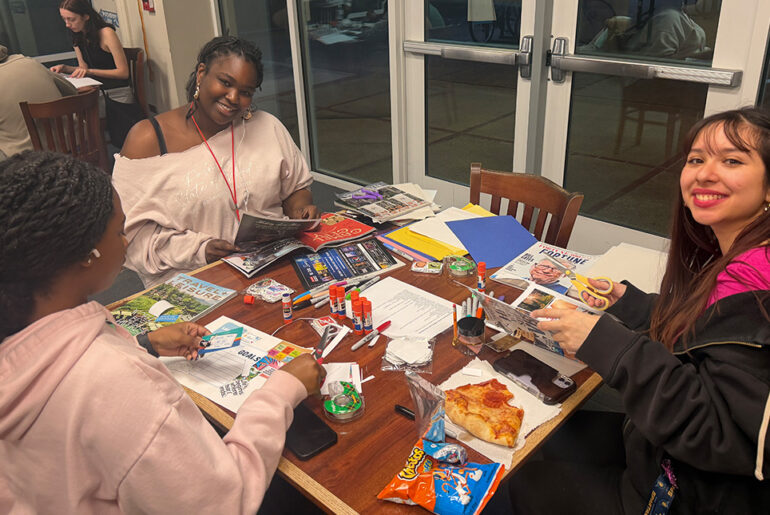 UNCG students around a table doing activities.
