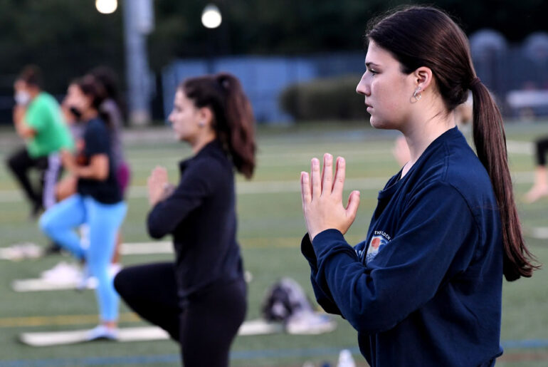 Students practicing yoga, which goes along with the theme of wellness.