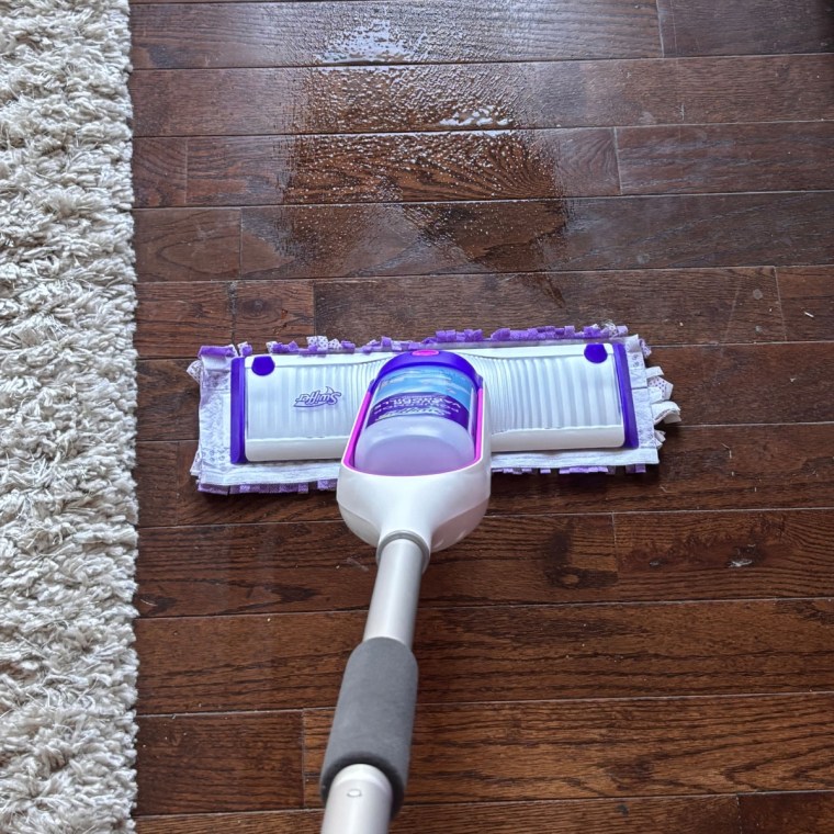 Swiffer PowerMop Multi-Surface Kit for Floor Cleaning on hardwood floors with cleaning solution sprayed.