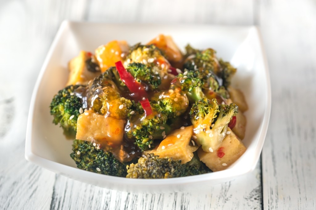 Tofu and broccoli stir-fry in a white bowl.