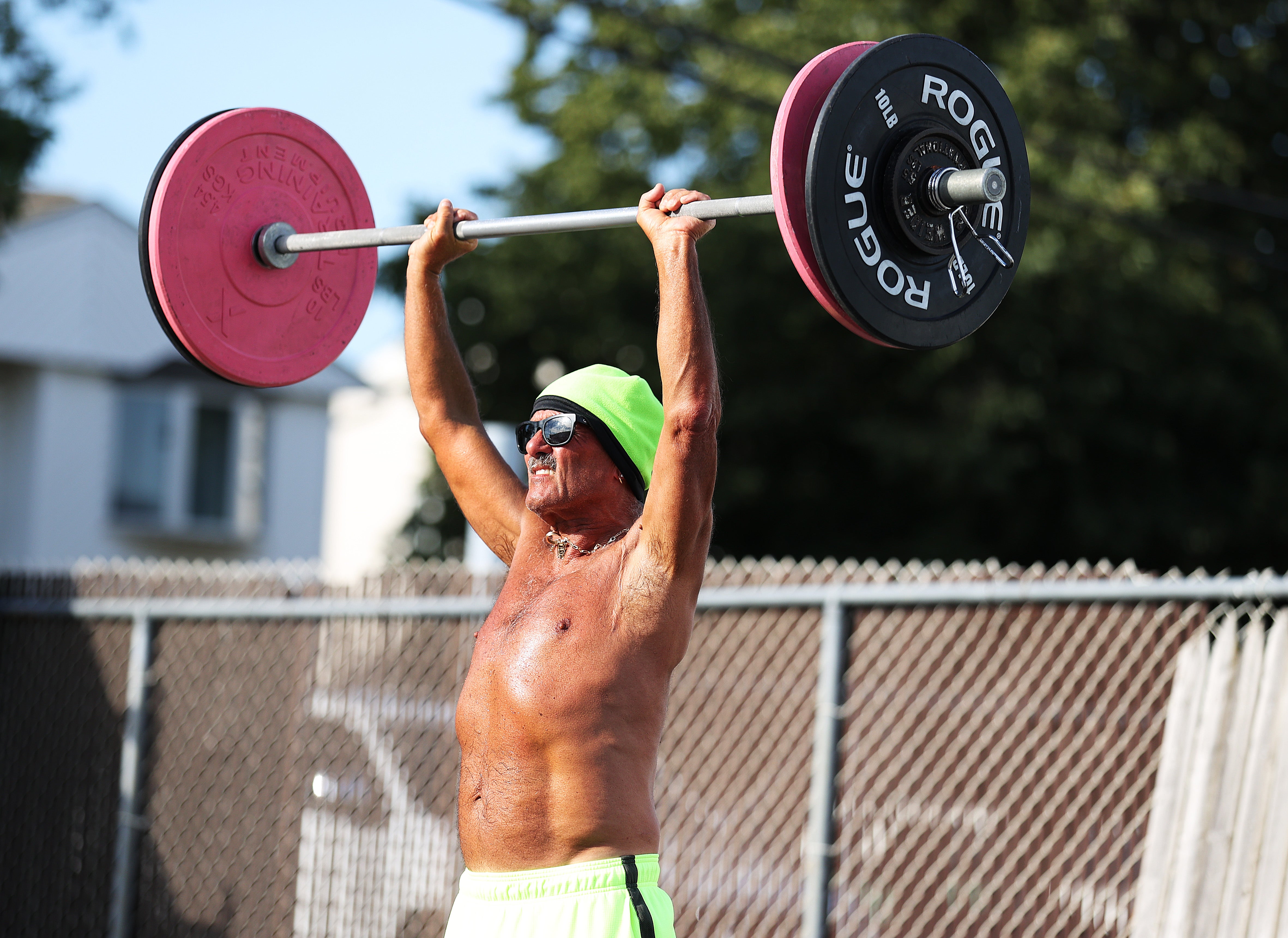 A man lifts a barbell over his head in July 2020 in Oceanside, New York. Getting enough vitamin B12 could help you make gains in the gym, a recent study found