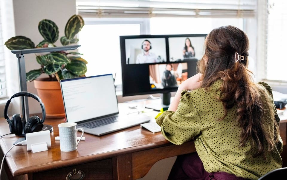 Woman working from home office having video call with business team