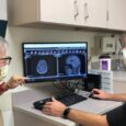 Trial participant Kim Garland (left) reviews a scan with the study’s primary investigator, Tanner Johanns, MD, PhD, a WashU Medicine oncologist