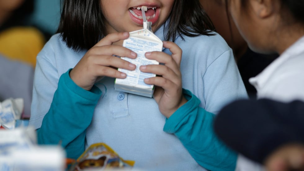 FILE - A student drinks milk in the cafeteria area of an elementary school in Los Angeles on...