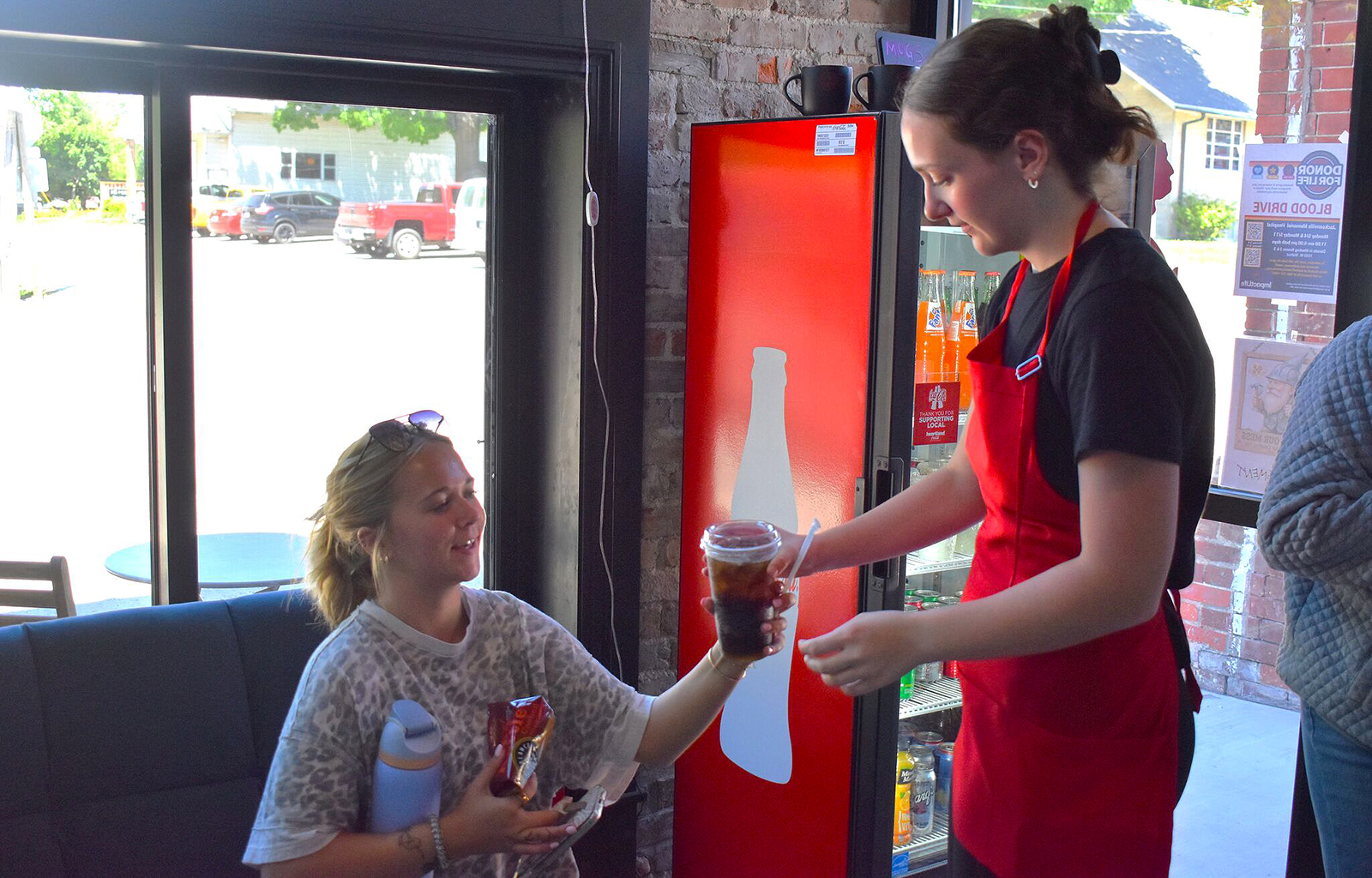 Ashlynn Mahan (left) takes her drink from Coddiwomple Coffee House in Franklin.