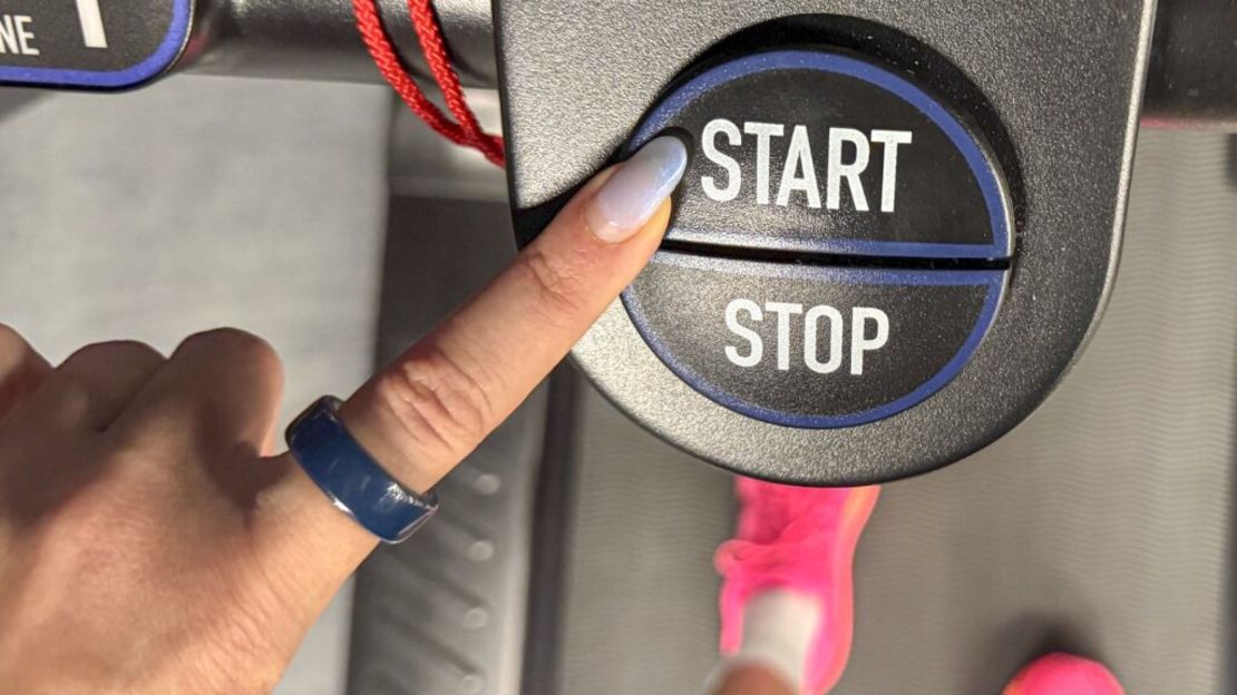 A woman wearing the Oura Ring 4 Ceramic presses 