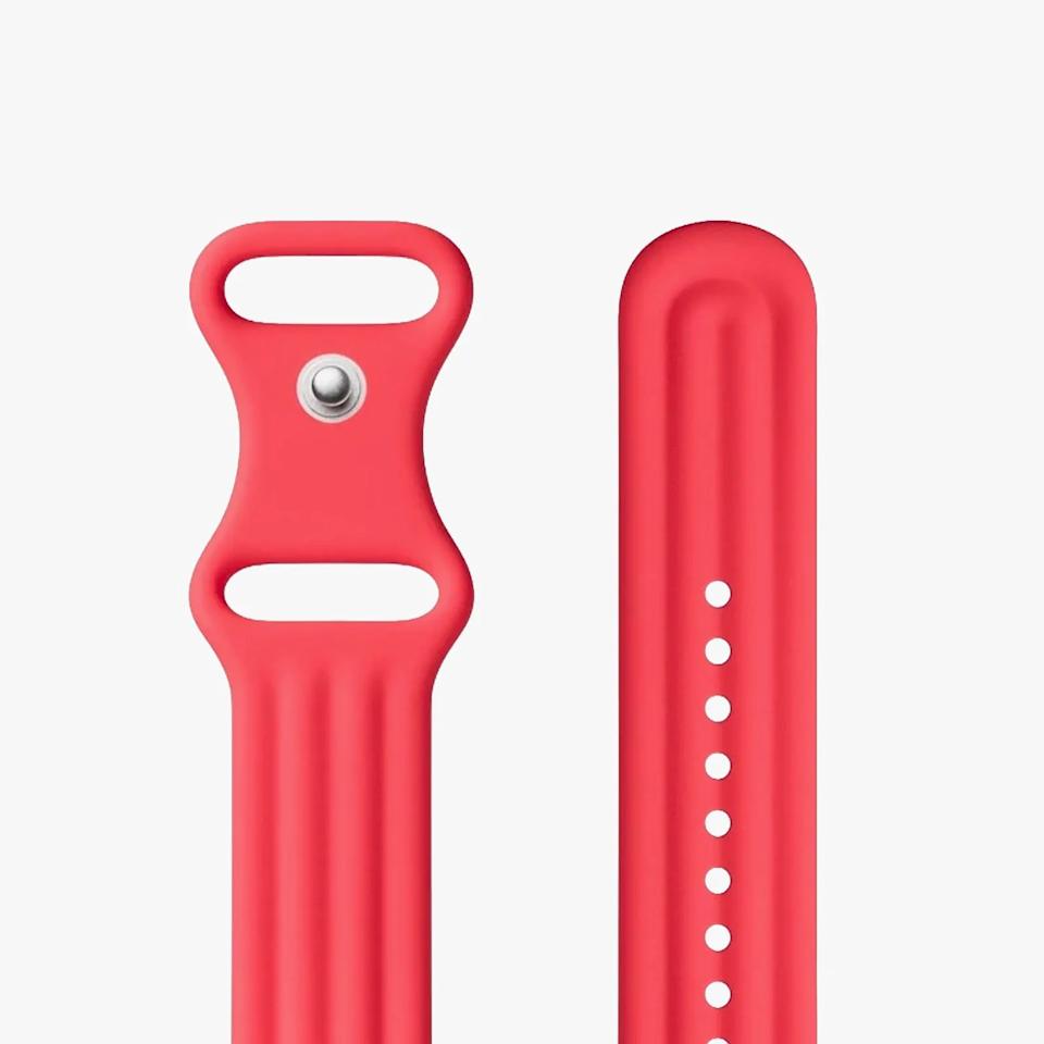 Red silicone watch band with a metal pin and multiple adjustment holes on a white background.