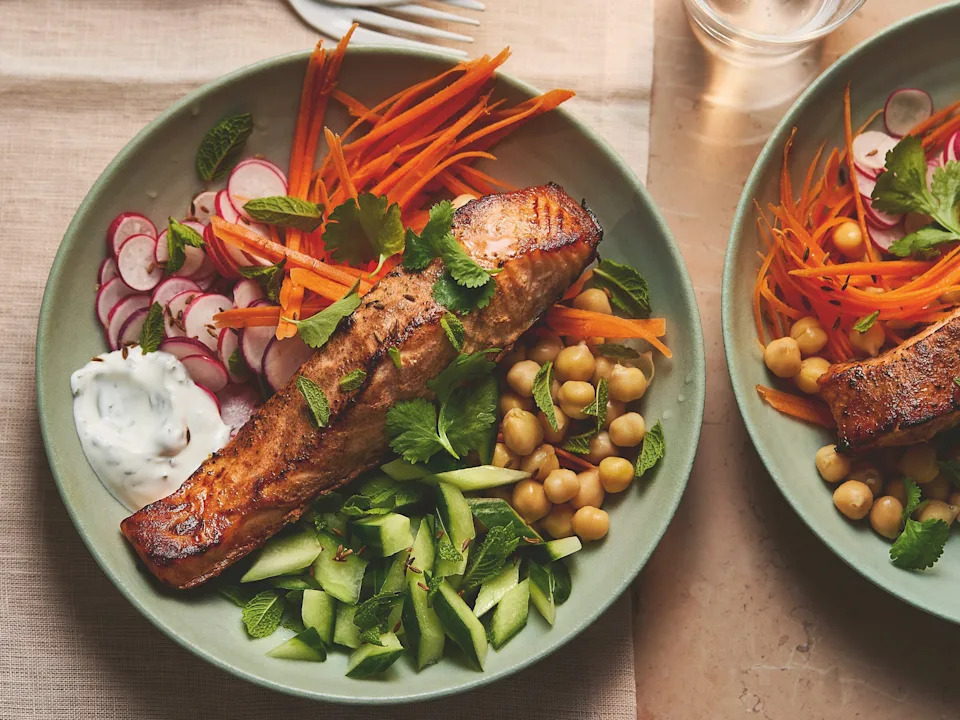 A bowl of baked salmon and veggies.