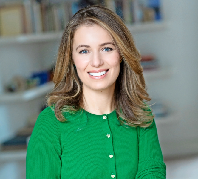 Dr. Federica Amati smiling in a green cardigan and jeans.