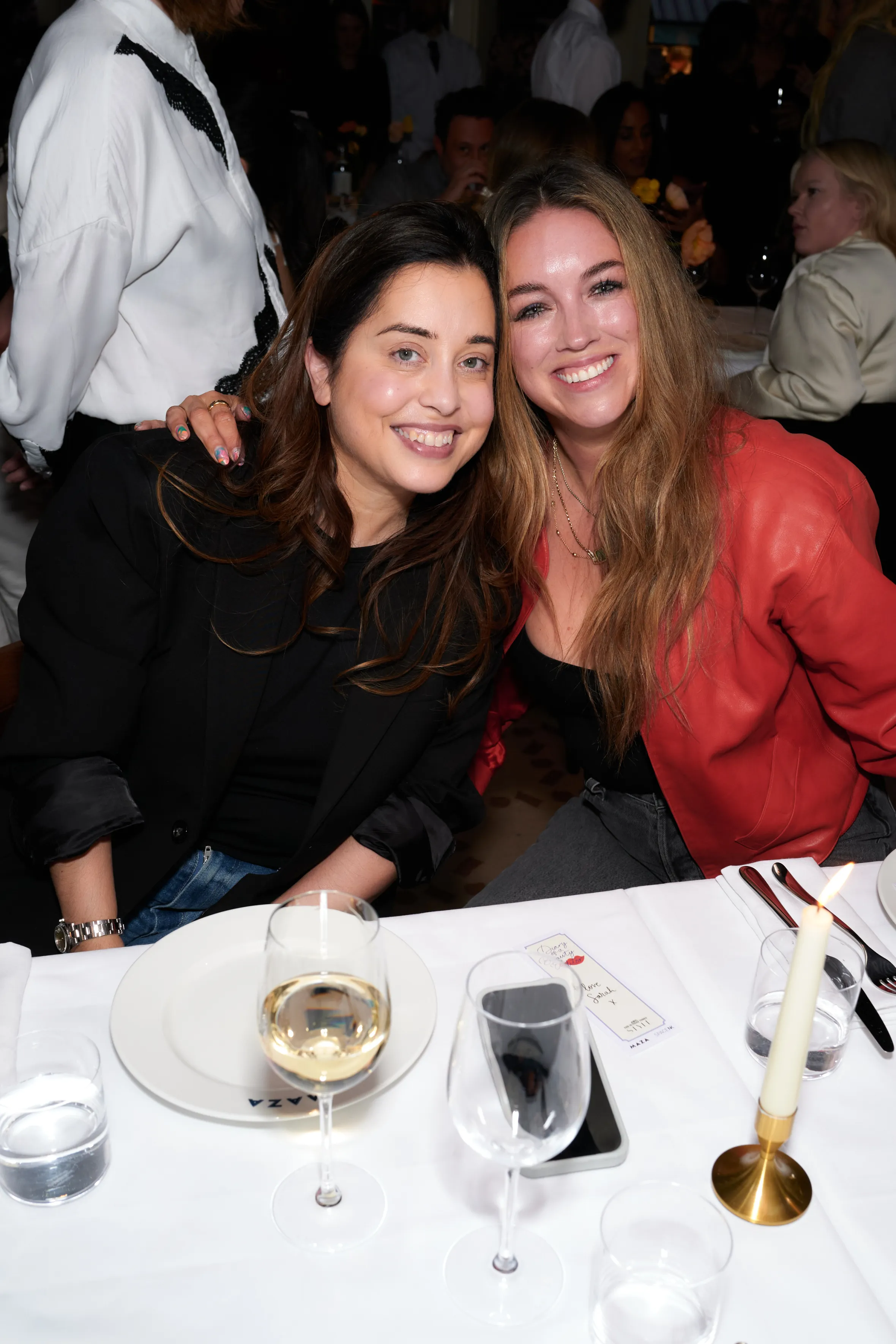 Two women smiling at a dining table.