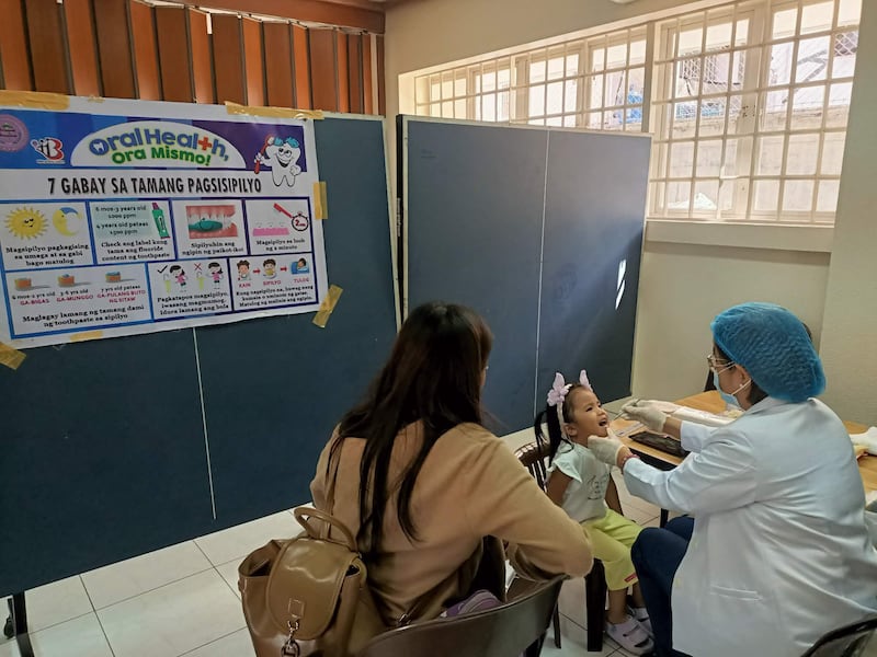 A health worker checks a girl's teeth during a screening held at the Caloocan Philippines Stake Center on Jan. 24, 2026.