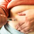 Someone injecting themselves in the abdomen with a semaglutide pen