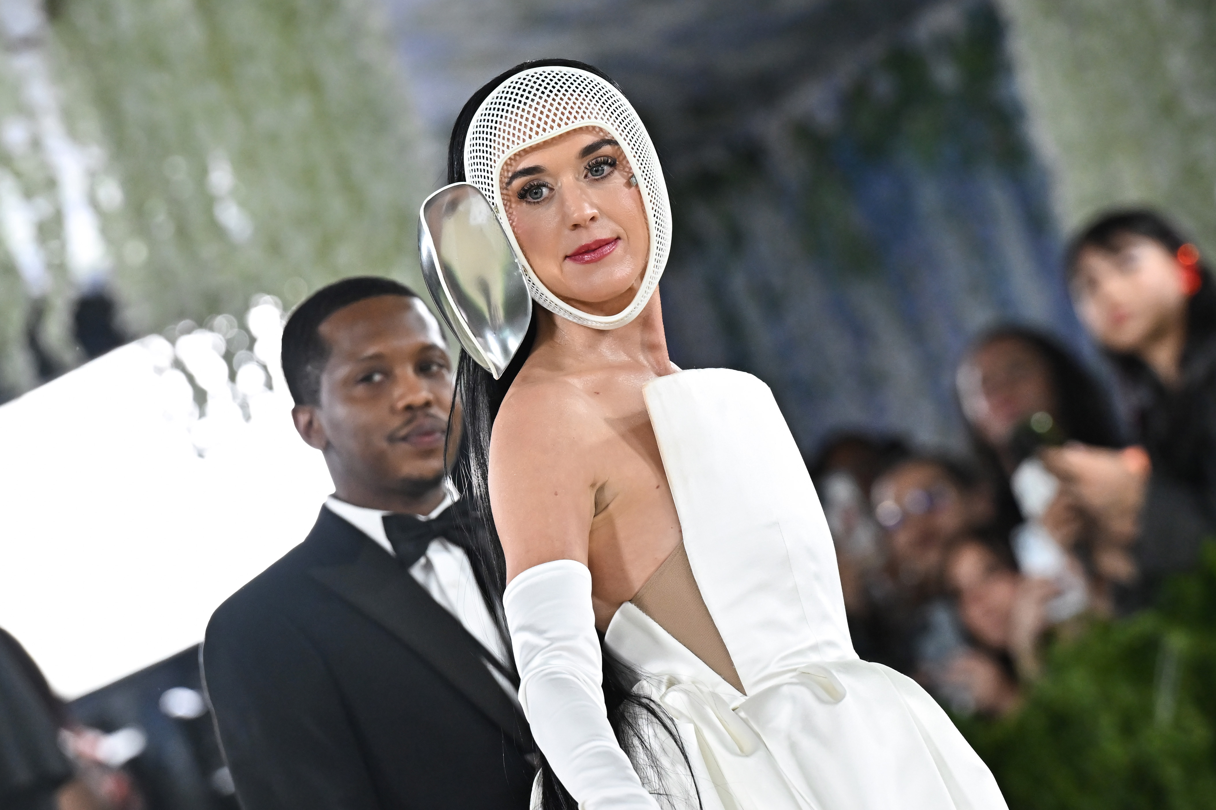 a woman in a white gown with a white mesh mask