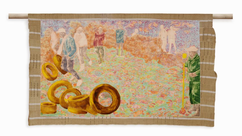 A textile painting showing scattered human figures and stacked tire-like forms in a pastel-colored landscape hangs from a wooden rod.