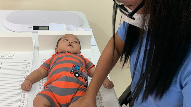 A health worker measures a baby's length during a screening at the Sipocot Philippines Stake Center on July 21, 2022.