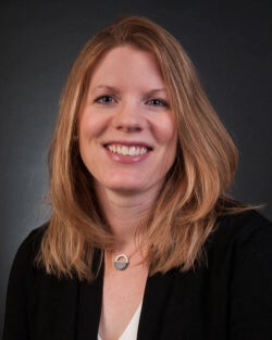 A woman, Amanda Winans, is photographed in professional attire.