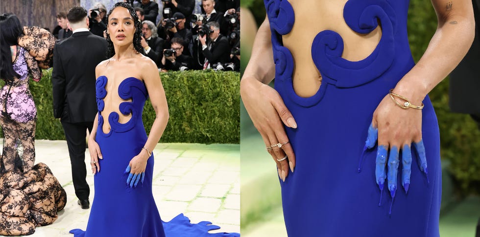 A fashion event scene highlighting a dramatic blue dress with unique cutouts and decorative details.