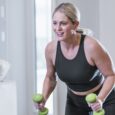 Woman exercising with dumbbells in domestic setting