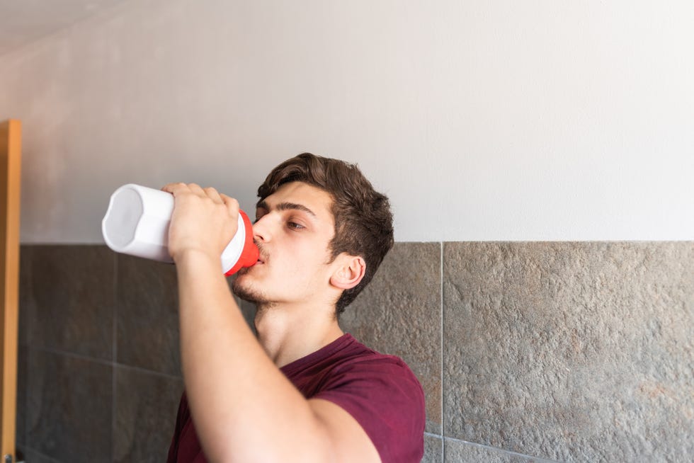 teenager drinking a protein shake after weight training teenager drinking a protein shake after weight training