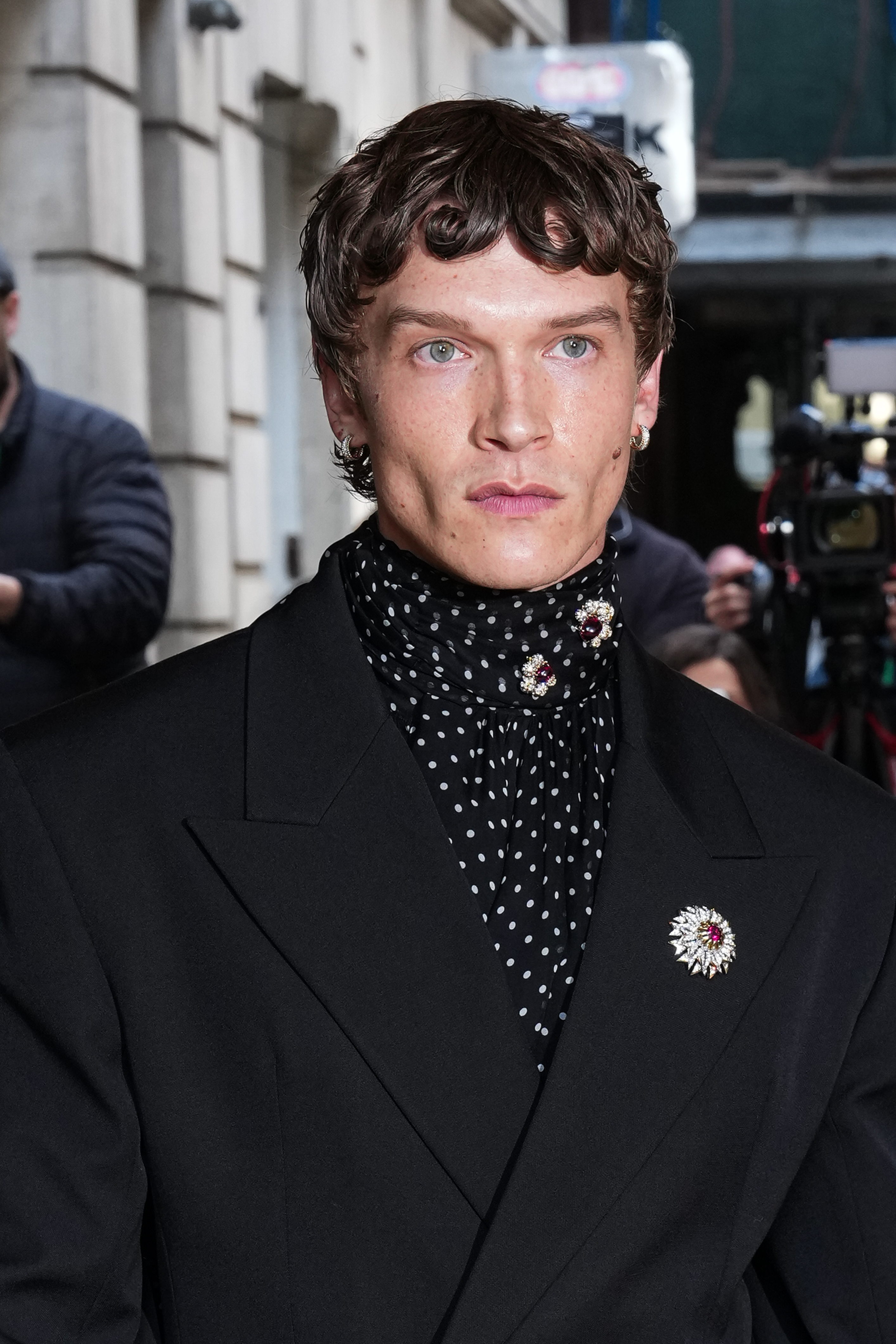 a man in a black suit with a polka dot cravat