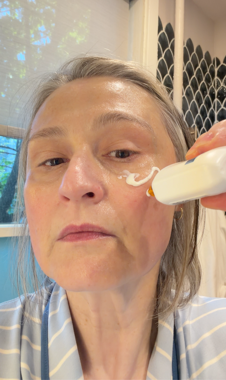 A person using a handheld device for skincare treatment.