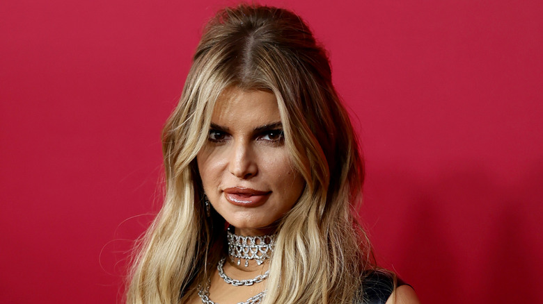 Jessica Simpson posing against a pink background