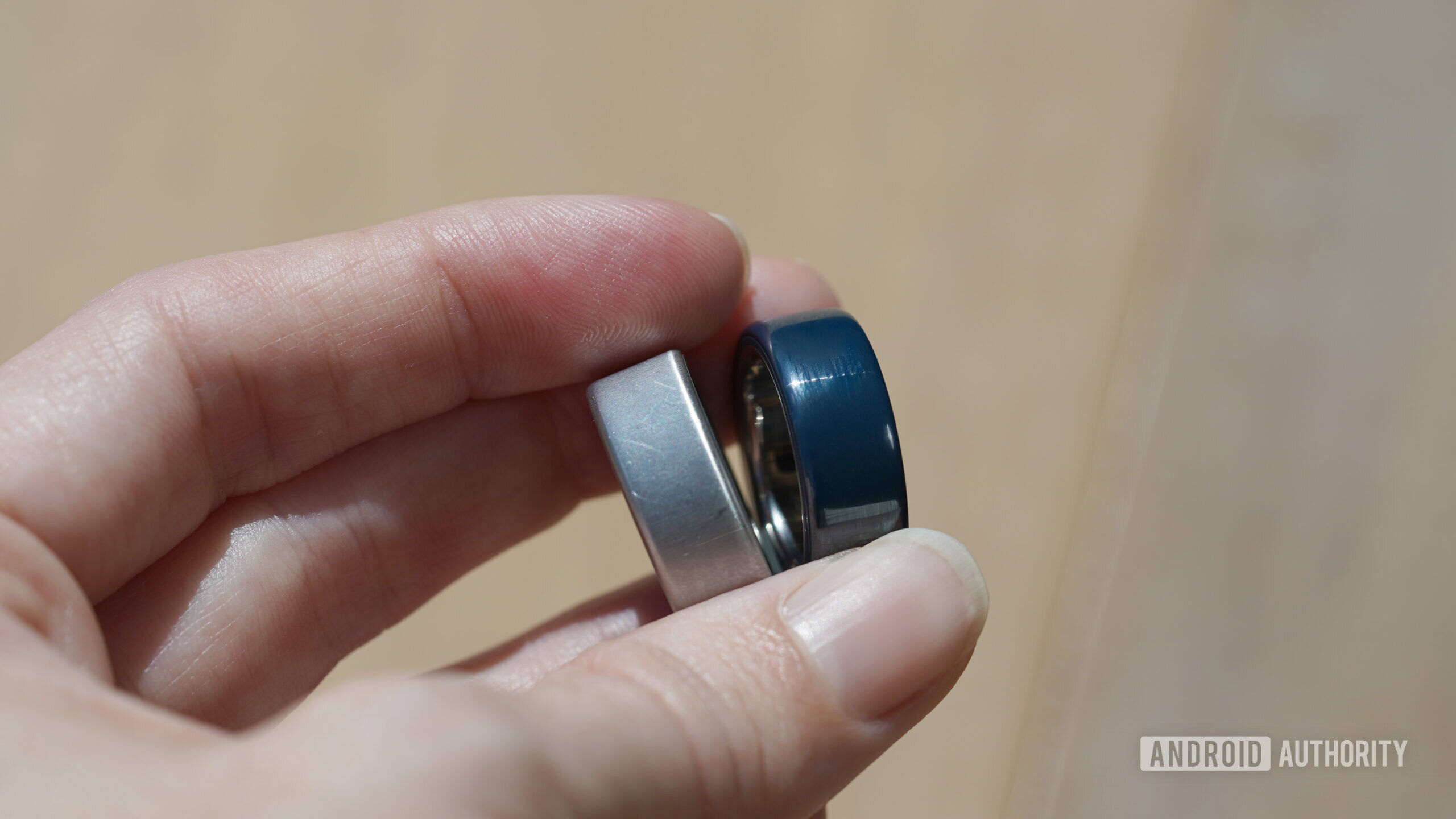A Oura user holds a ceramic and metallic model in hand.