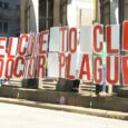 Protesters hold sign which reads "Welcome to Cle Dr. Plague" outside The City Club of Cleveland during a forum featuring Robert F. Kennedy, Jr.