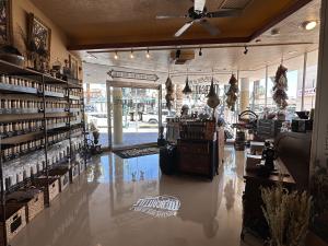 Mountain Rose Herbs (MRH), an Oregon-based e-commerce company known for its organic and sustainably sourced wellness products, is opening its third West Coast store location in the heart of downtown Palm Springs, California Image features an indoor photo of Mountain Rose Herb's new mercantile storefront opening up in Palm Springs this June. Dried flower displays hang from the floor-to-ceiling windows at the front, shelves lined with products, and an image of the Mountain Ros