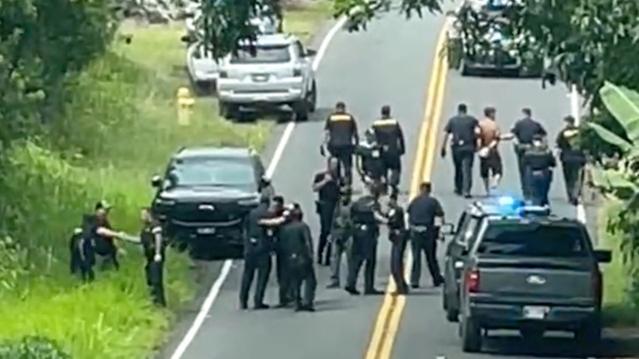 Police arrest a man accused of multiple killings, right, on Thursday, May 28, 2026, in Kaimu, Hawaii. (Deborah Davis via AP)