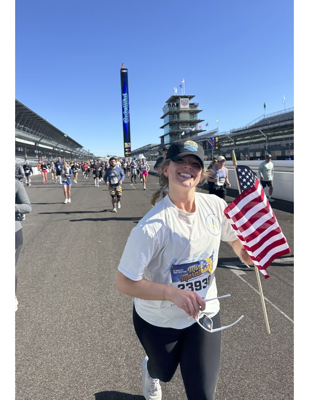 Sarah Molander holds an American flag while running on the Indianapolis Motor Speedway.