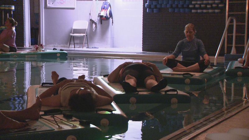 People in a floating sound bath on specialized water mats. (WJAR)